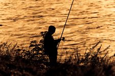 Fisherman Silhouette On Sunset. Stock Photography