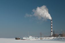 Smoking Chimney Over Frozen Lake Royalty Free Stock Image