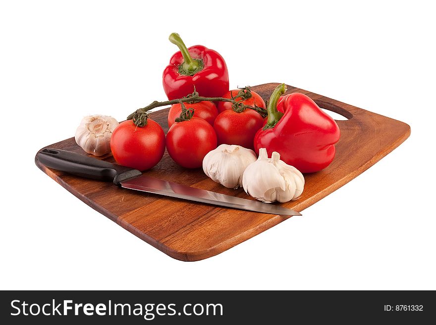 Garlic, tomatoes and peppers on cutting board isolated on white background. Garlic, tomatoes and peppers on cutting board isolated on white background