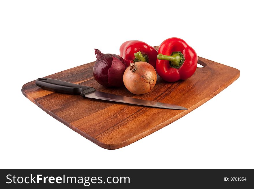 Onions, peppers and knife on cutting board isolated on white background. Onions, peppers and knife on cutting board isolated on white background