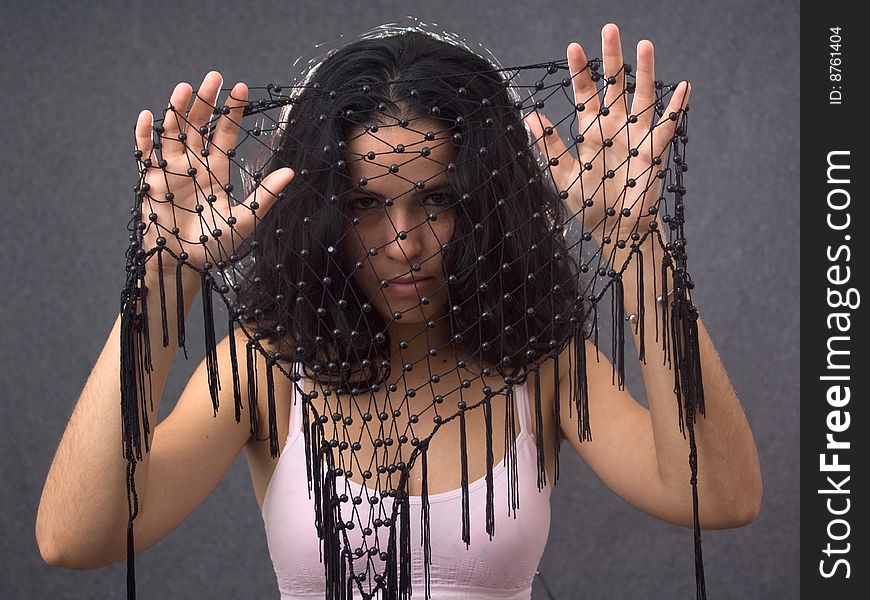 Pretty girl looking through a black balls net