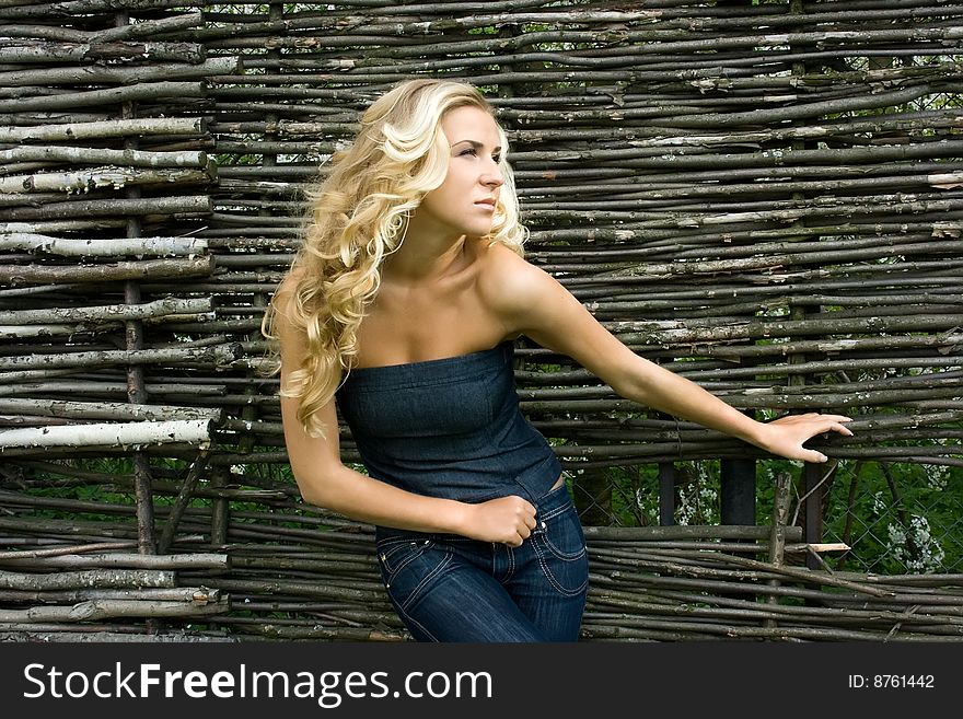 Young blonde girl standing at the fence