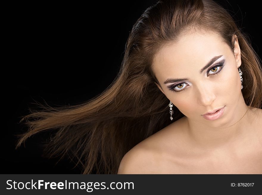 The beautiful woman with a flying hair on a black background. The beautiful woman with a flying hair on a black background