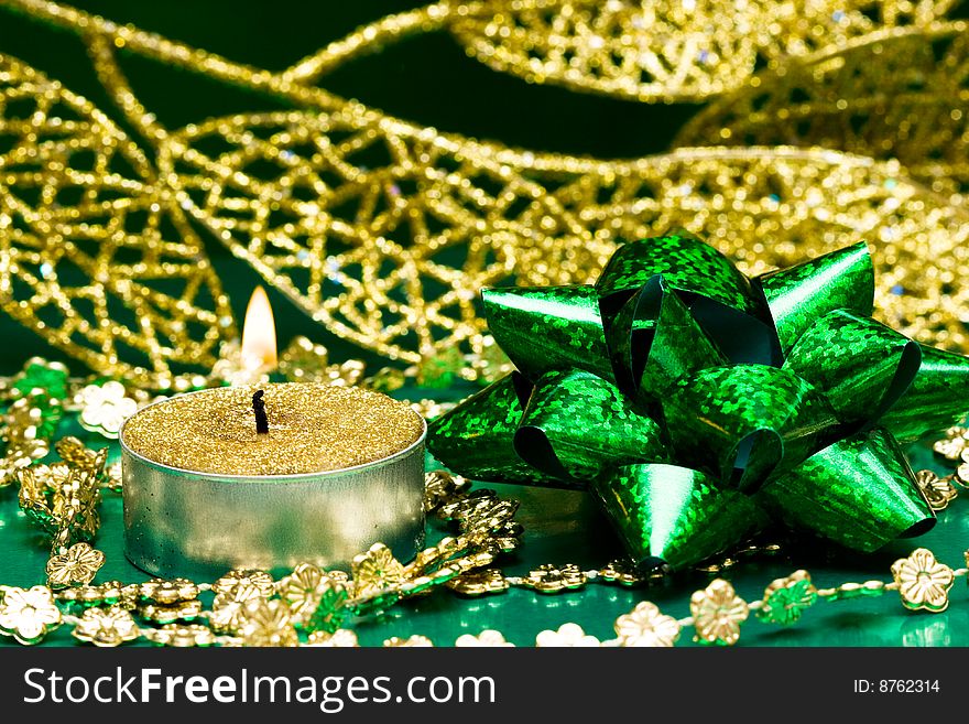 Green festive bow and burning candle