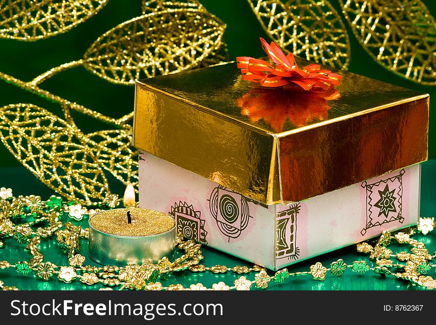 Golden gift box and burning candle