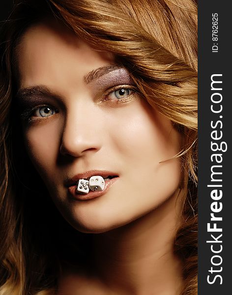 Fashion girl portrait with dice in her mouth. Fashion girl portrait with dice in her mouth