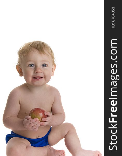 Happy baby holds and eats apple. Happy baby holds and eats apple