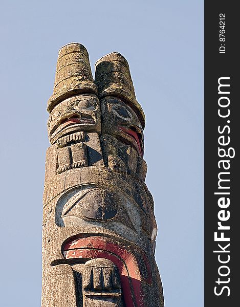 Pacific northwest totem pole against blue sky