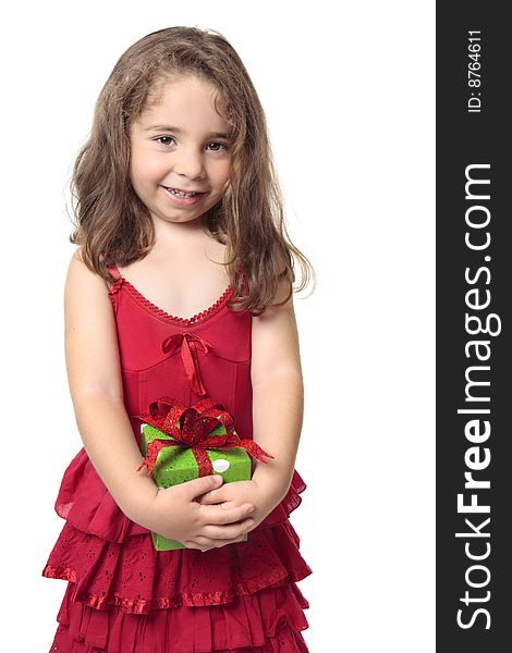 Little girl in a red dress holds a green and red present and smiles sweetly. Little girl in a red dress holds a green and red present and smiles sweetly.