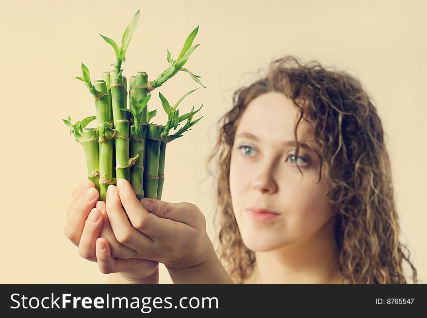 An image of a pretty woman with green bamboo. An image of a pretty woman with green bamboo