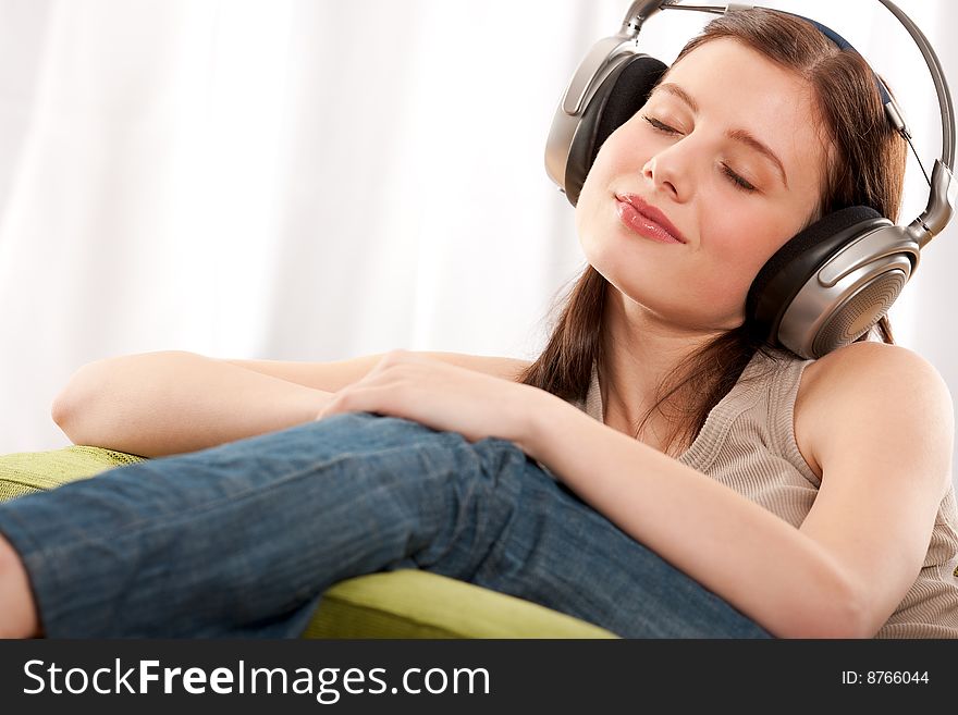 Young brunette enjoying music in the living room. Young brunette enjoying music in the living room