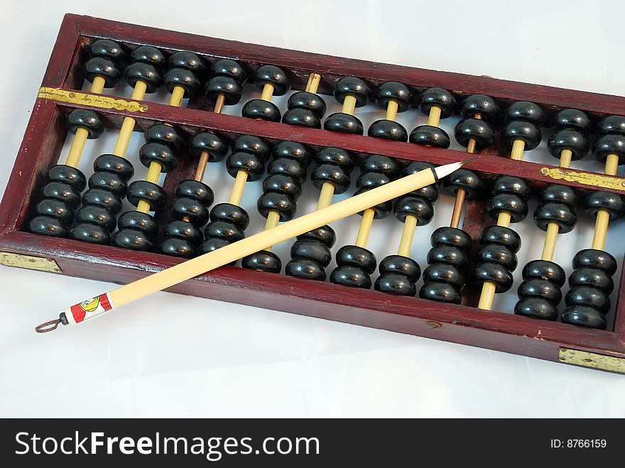 A Brush is on an abacus ,which is on white Background. A Brush is on an abacus ,which is on white Background