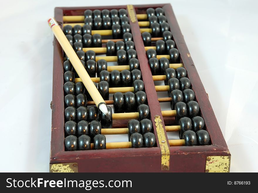 A Brush is on an abacus ,which is on white Background. A Brush is on an abacus ,which is on white Background