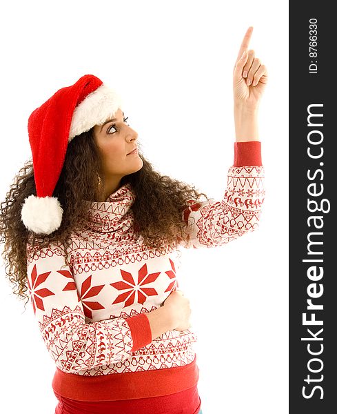 Cute young woman wearing red christmas hat and pointing upwards on an isolated white background