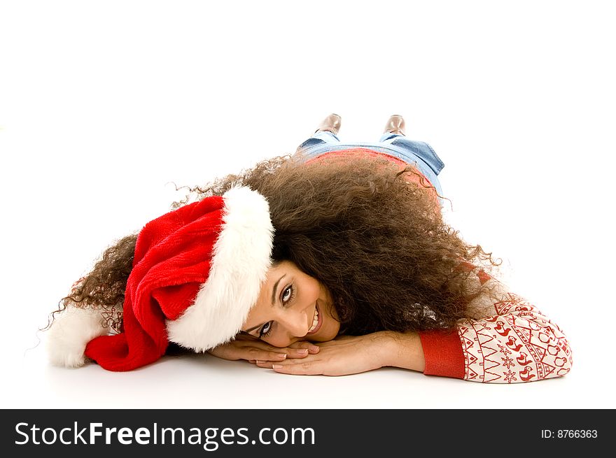 Cute young woman wearing red christmas hat and resting on the floor on an isolated white background