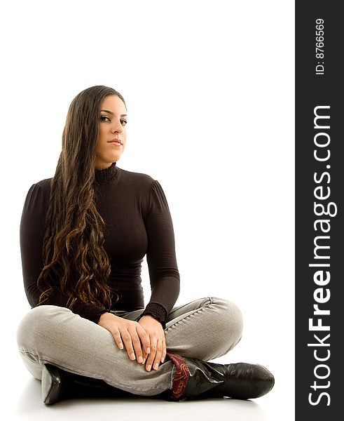 Fashionable woman sitting on the floor and looking sideways with white background