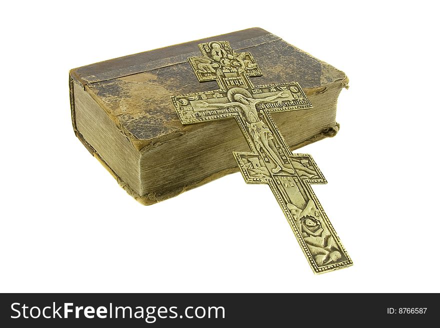 Very old vintage bible and big church cross near to it isolated over white background