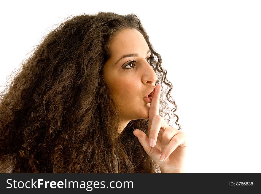 Hispanic female shushing with finger against white background