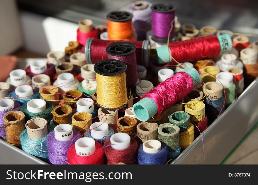 Coils with multi-coloured threads for sewing are packed in a box