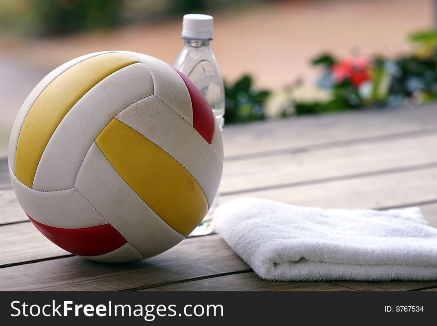 Volleyball, bottle water and towel on the wooden ground. Volleyball, bottle water and towel on the wooden ground