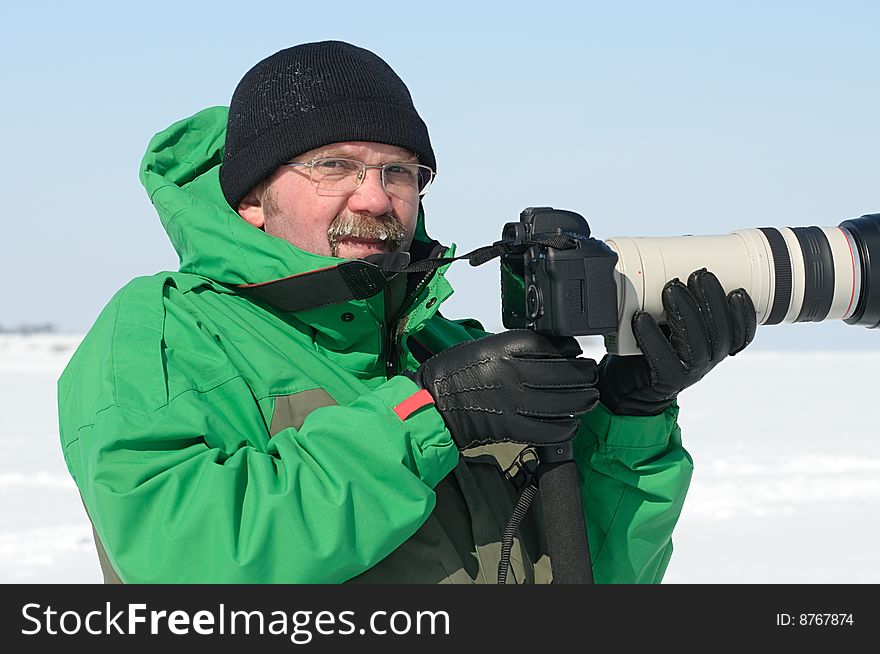 Photographer on  winter assignment with zoom lens. Photographer on  winter assignment with zoom lens