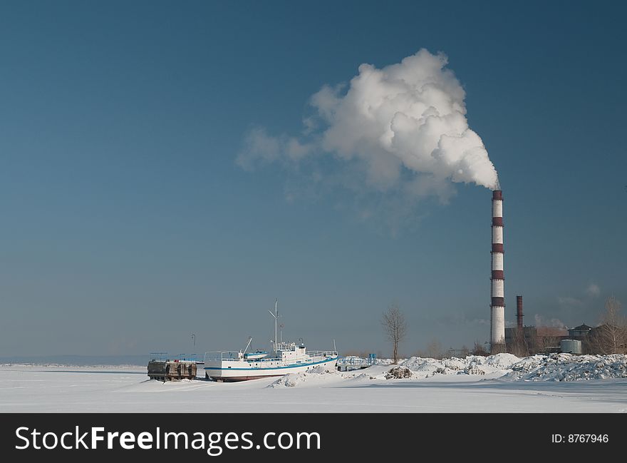 Smoking Chimney Over Frozen Lake