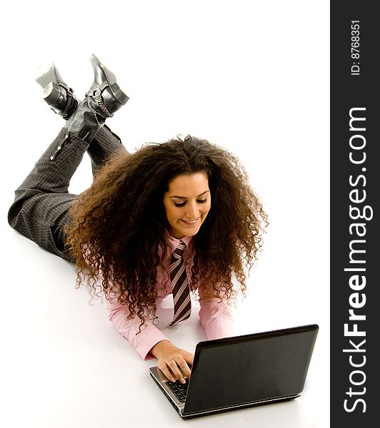 Young female lying on floor working on laptop with white background