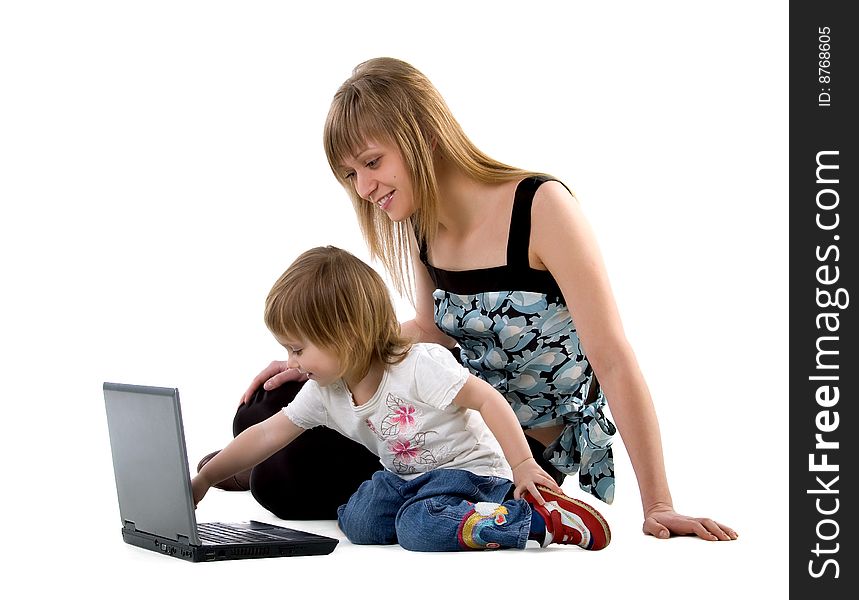 Little girl and her mother sits near laptop