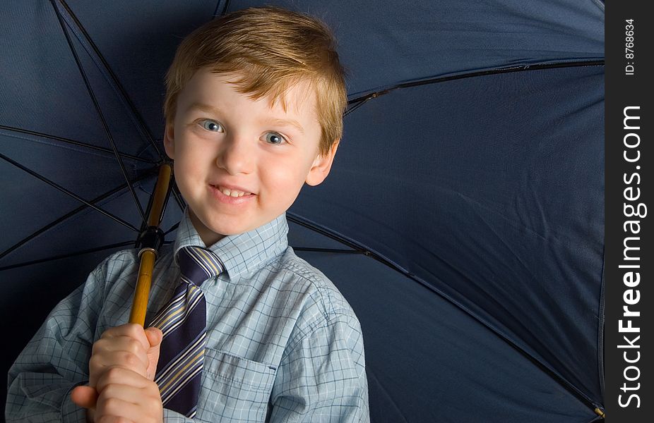 Young boy in shirt and tie poses with blue umbrella. Young boy in shirt and tie poses with blue umbrella