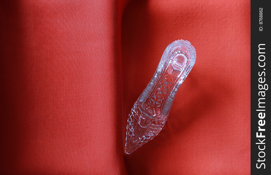 Nice glass slipper standing on stairs with red cloth. Nice glass slipper standing on stairs with red cloth