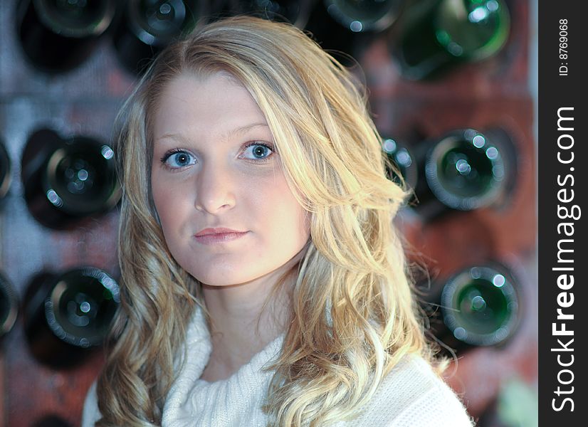 Attractive bond teen in front of wine rack. Attractive bond teen in front of wine rack