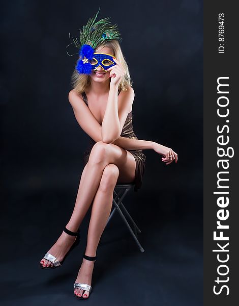 Beautiful girl in carnival mask against a dark background. Beautiful girl in carnival mask against a dark background