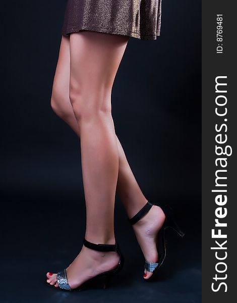 Beautiful female legs against a dark background. Beautiful female legs against a dark background