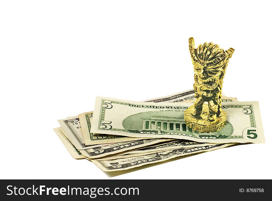 A golden figurine of Hawaiian God of money on a stack of US dollars. Isolated on white. A golden figurine of Hawaiian God of money on a stack of US dollars. Isolated on white