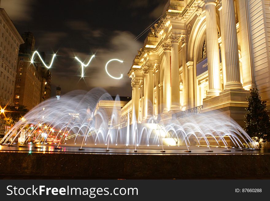 A view from New York City at night with a fountain. A view from New York City at night with a fountain.