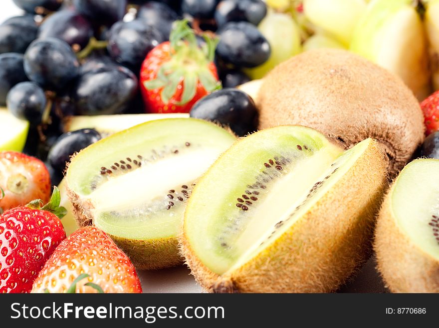 Assorted fresh fruits background including strawberry, apple, kiwi and black and green grape