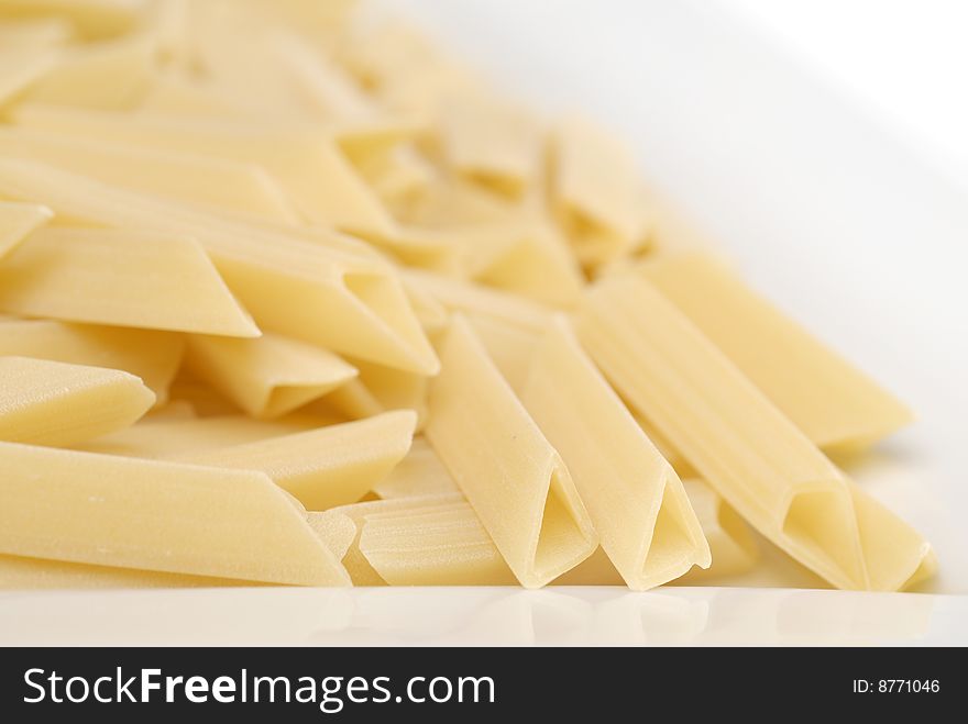 Raw macaroni on the white table