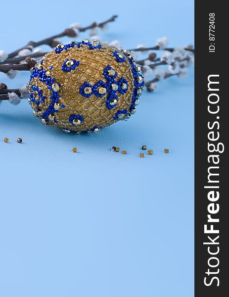 Bead easter egg and sprigs of pussy-willow on a blue background. Bead easter egg and sprigs of pussy-willow on a blue background