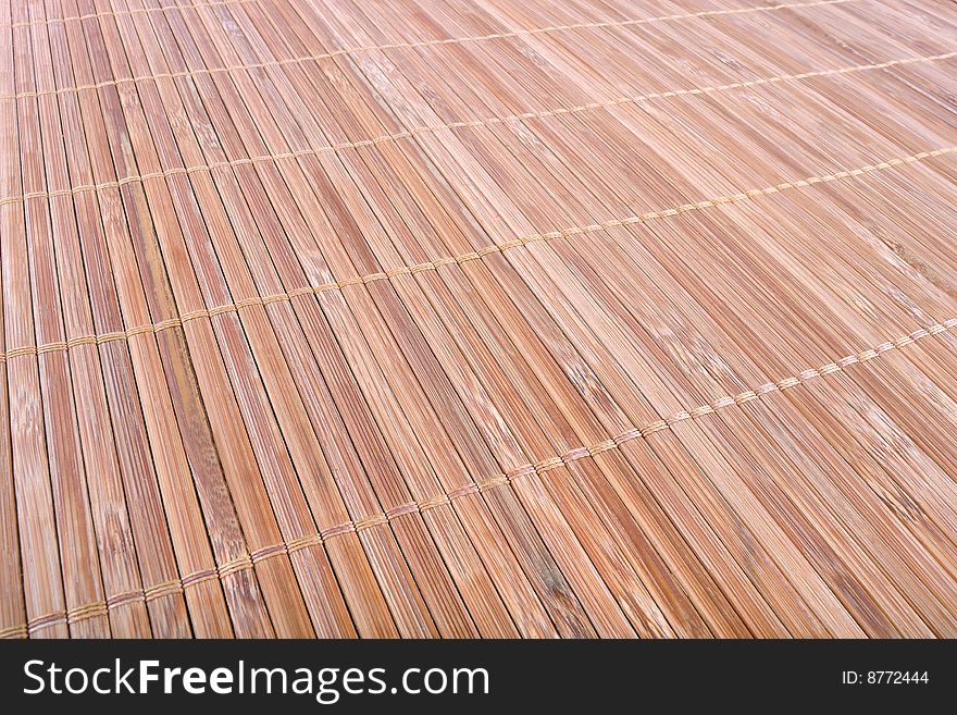 Light brown mat of bamboo strips bound together as a background