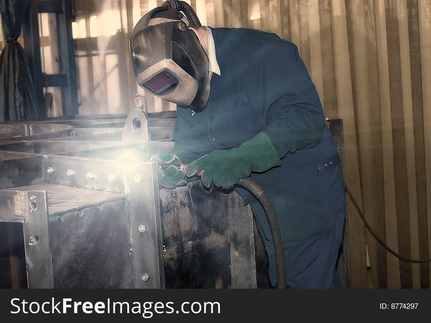 Man is weldind a big place of steel. Man is weldind a big place of steel