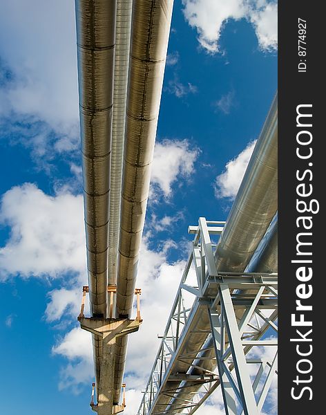 Industrial pipelines on pipe-bridge against blue sky. Industrial pipelines on pipe-bridge against blue sky.