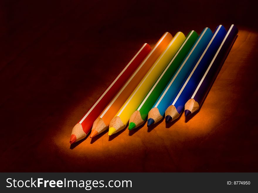 Colored pencils against a black background. Colored pencils against a black background