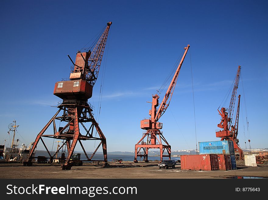 Harbor with three crane under blue sky