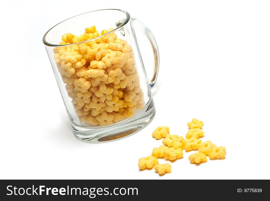 Glass cup full dry morning meal, disposit flakes on white background