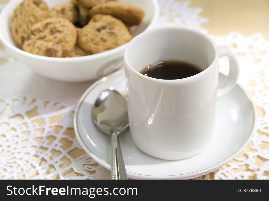 The white coffee cup and cookies.