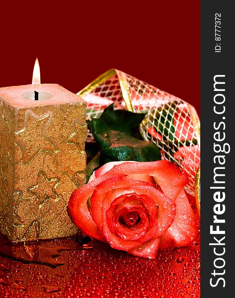 Golden candle with red rose