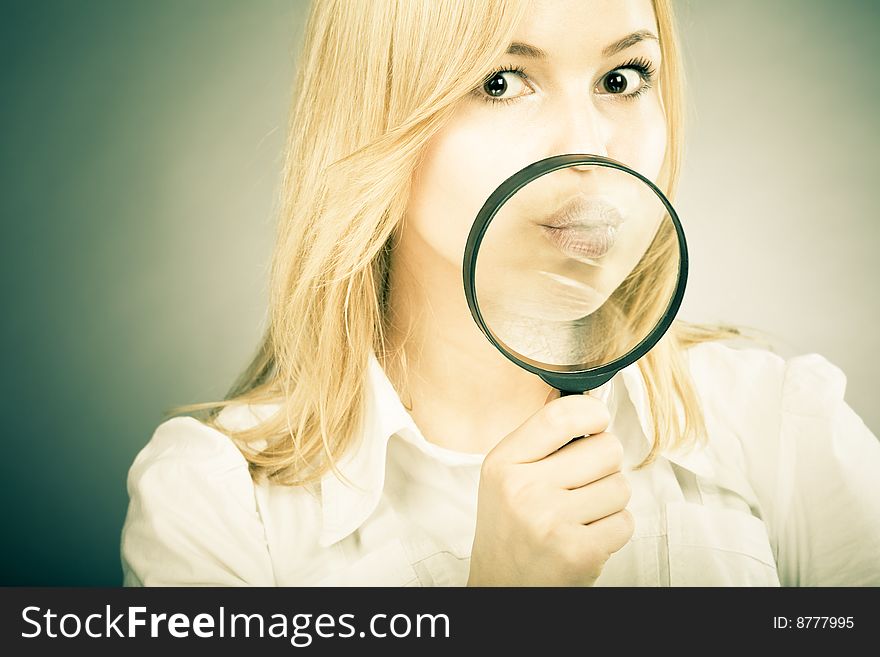 Excited girl with a loupe in her hand looking to camera. Fun business concept image with colored effect. Excited girl with a loupe in her hand looking to camera. Fun business concept image with colored effect