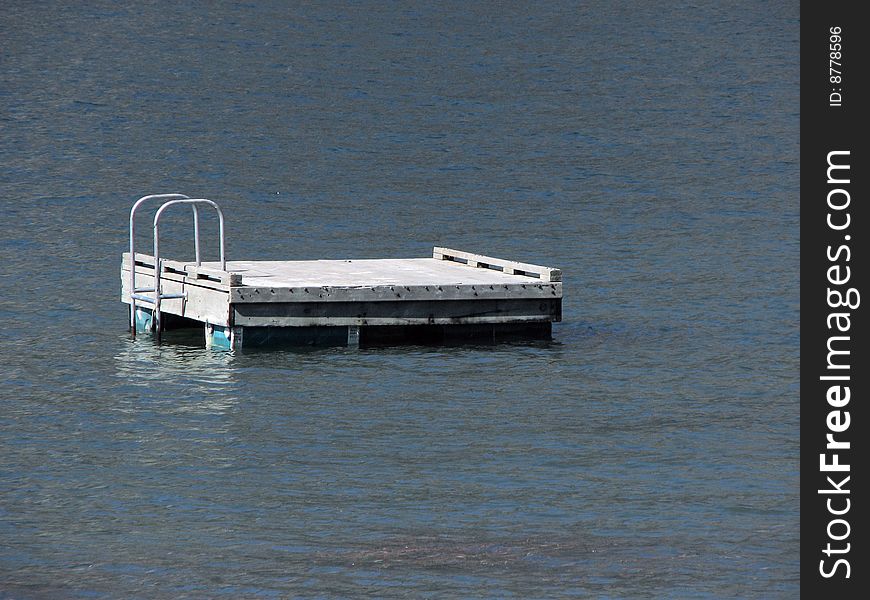 A picture of a floating dock for swimmers to use. There is a ladder at one end of the platform so they can climb up to sun tan or dive off or whatever. A picture of a floating dock for swimmers to use. There is a ladder at one end of the platform so they can climb up to sun tan or dive off or whatever.