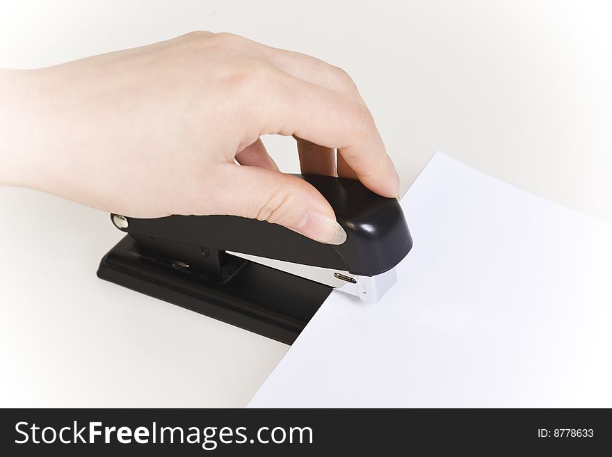 Hand pushing down an stapler isolated on white. Hand pushing down an stapler isolated on white.