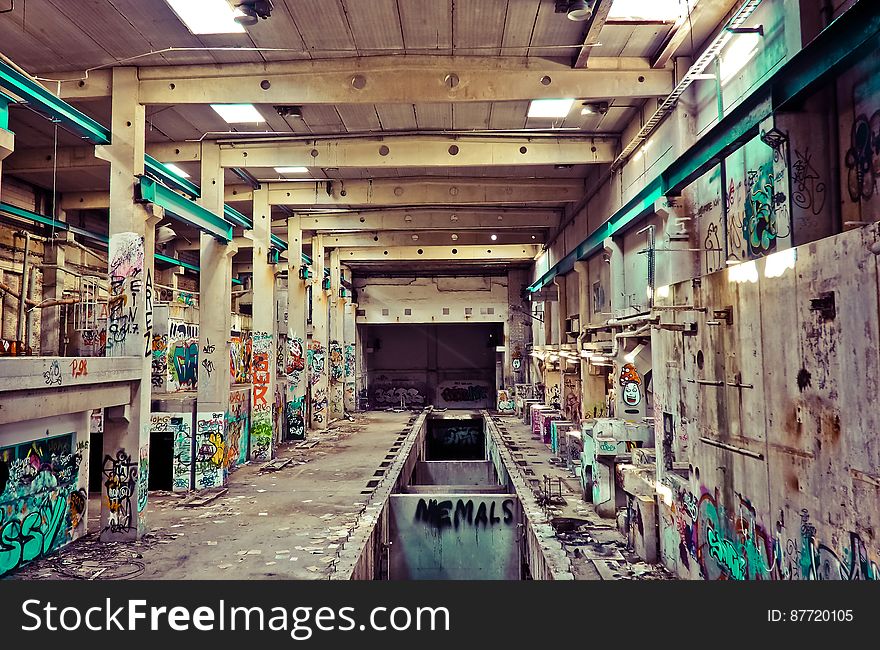 Interior of abandoned factory with colorful graffiti.